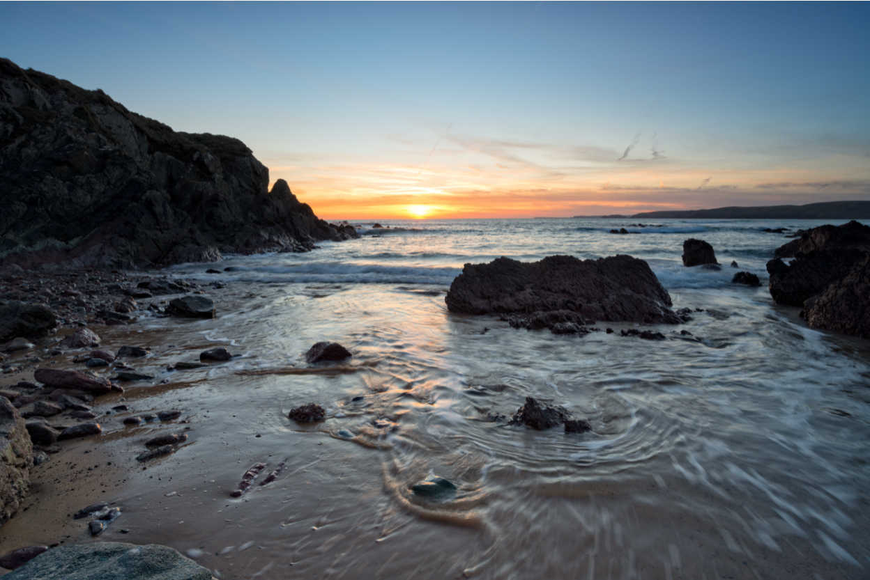 Beautiful sunset over the rocks on Freshwater West beach in the Pembrokeshire Coast National Park in Wales
